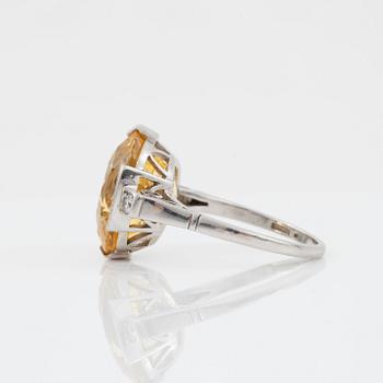 A circa 13.50 ct fancy yellow sapphire and brilliant-cut diamond ring. Total carat weight of diamonds circa 0.10 ct.