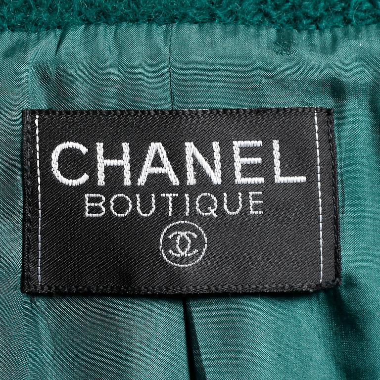 CHANEL, a two-piece suit consisting of short jacket and skirt.