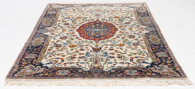 A Tabriz rug, signed, approx. 239 x 153 cm.