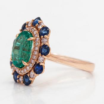 A 14K rosegold ring with an emerald  2.48 ct, sapphires ca 1.17 ct, and diamonds ca. 0.48 ct. With IGI certificate.