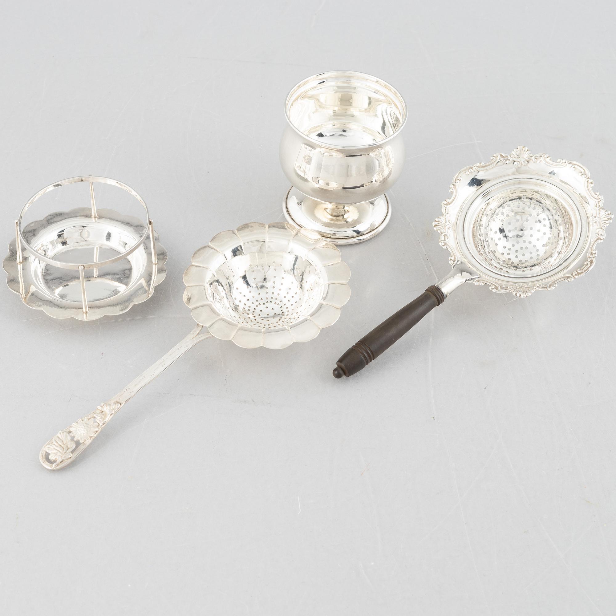 Two sterling silver tea strainers with stands, 20th century.