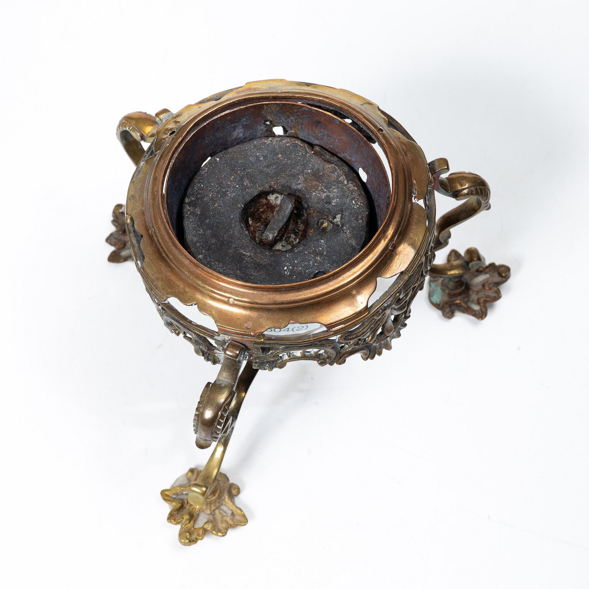 A German Rococo repoussé copper teapot on rechaud, mid 18th century.