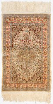 A silk Hereke rug, c. 85 x 55 cm.