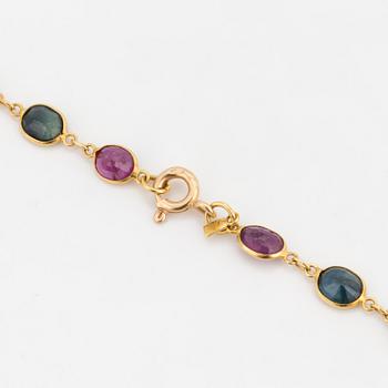 A necklace set with oval, mixed-cut, multi-coloured gemstones.