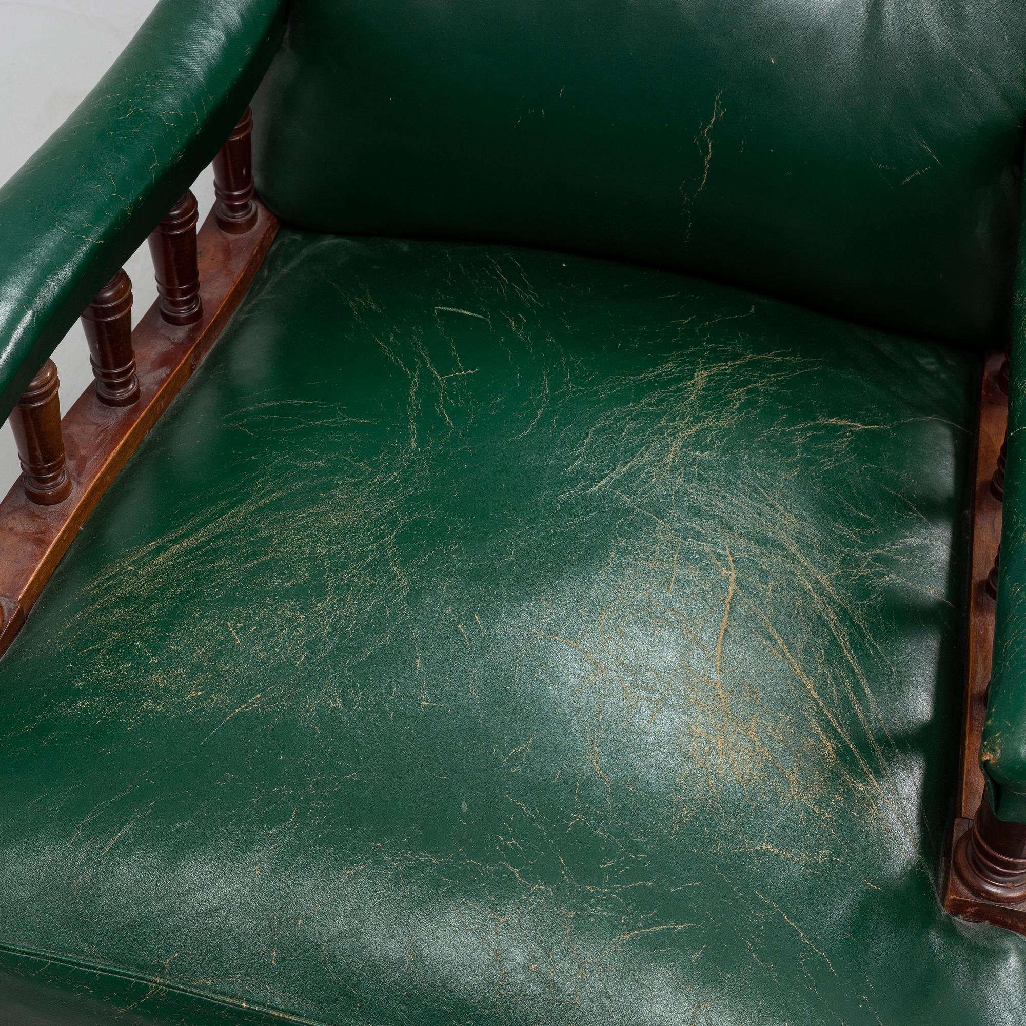 An early 20th Century easy chair with leather upholstery.