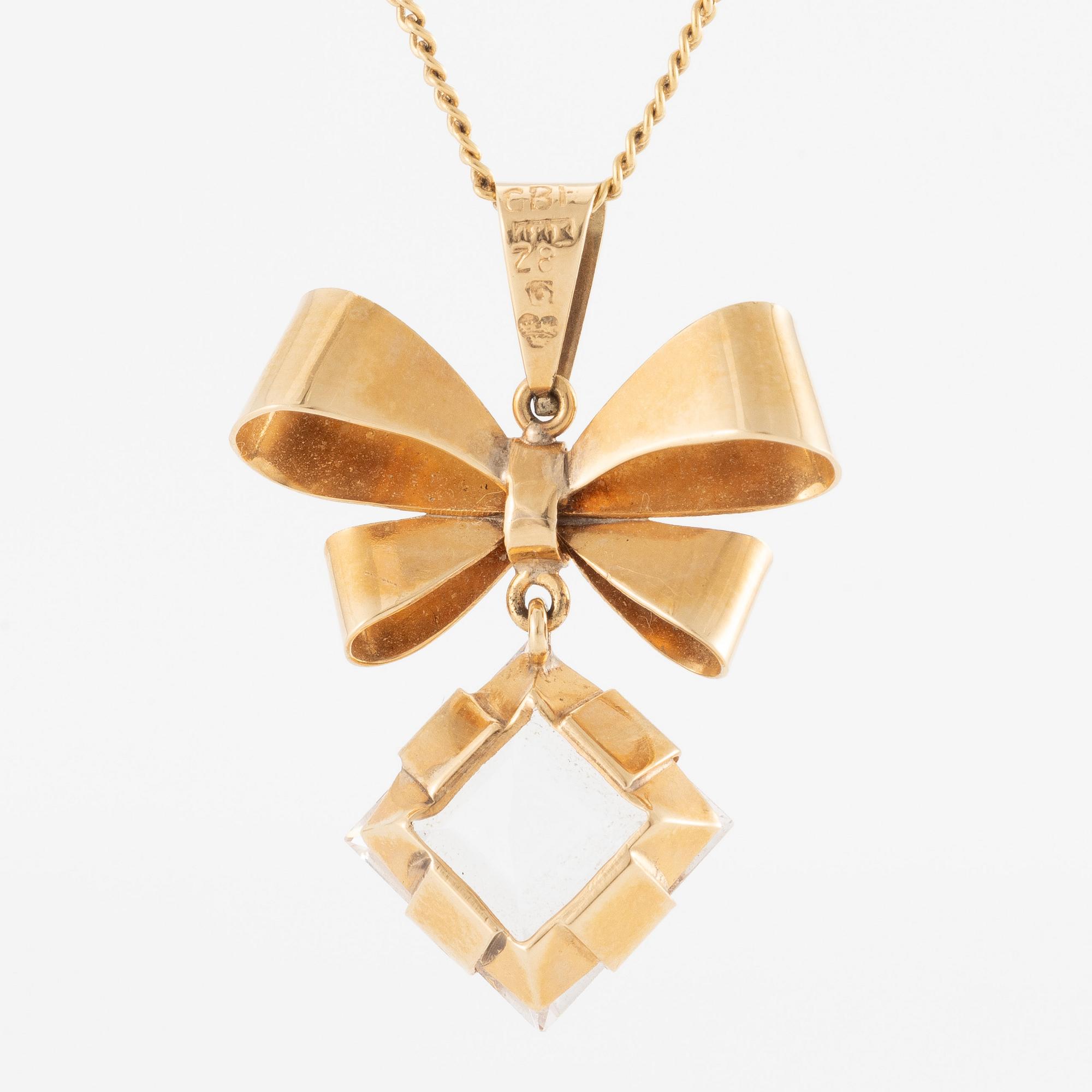 Necklace, 18K gold with synthetic white stone, in the shape of a bow.