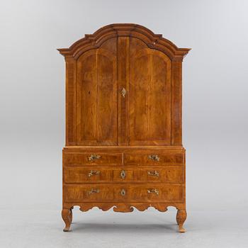 A walnut-veneered rococo cabinet in the manner of C. Linning, later part of the 18th Century.