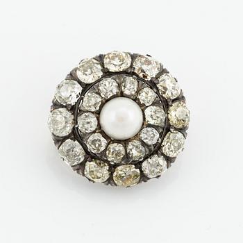 A silver and gold brooch, with cushion-cut diamonds and a pearl.