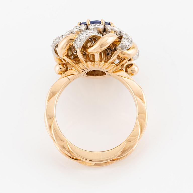 An 18K gold  ring with a sapphire and round brilliant-cut diamonds.