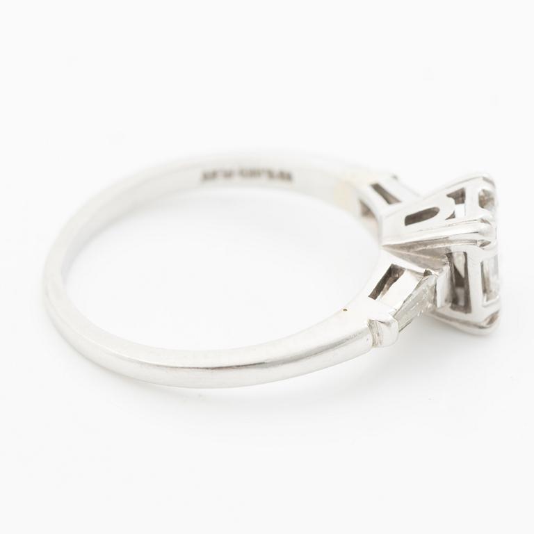 Platinum ring with an emerald-cut diamond and modified baguette-cut diamonds.