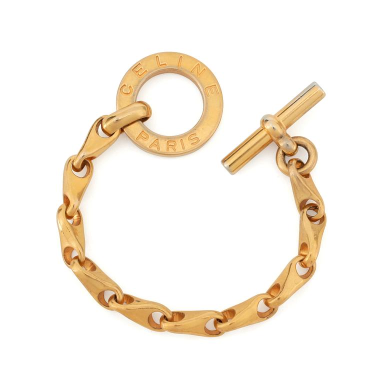 CÈLINE, a gold coloured bracelet.