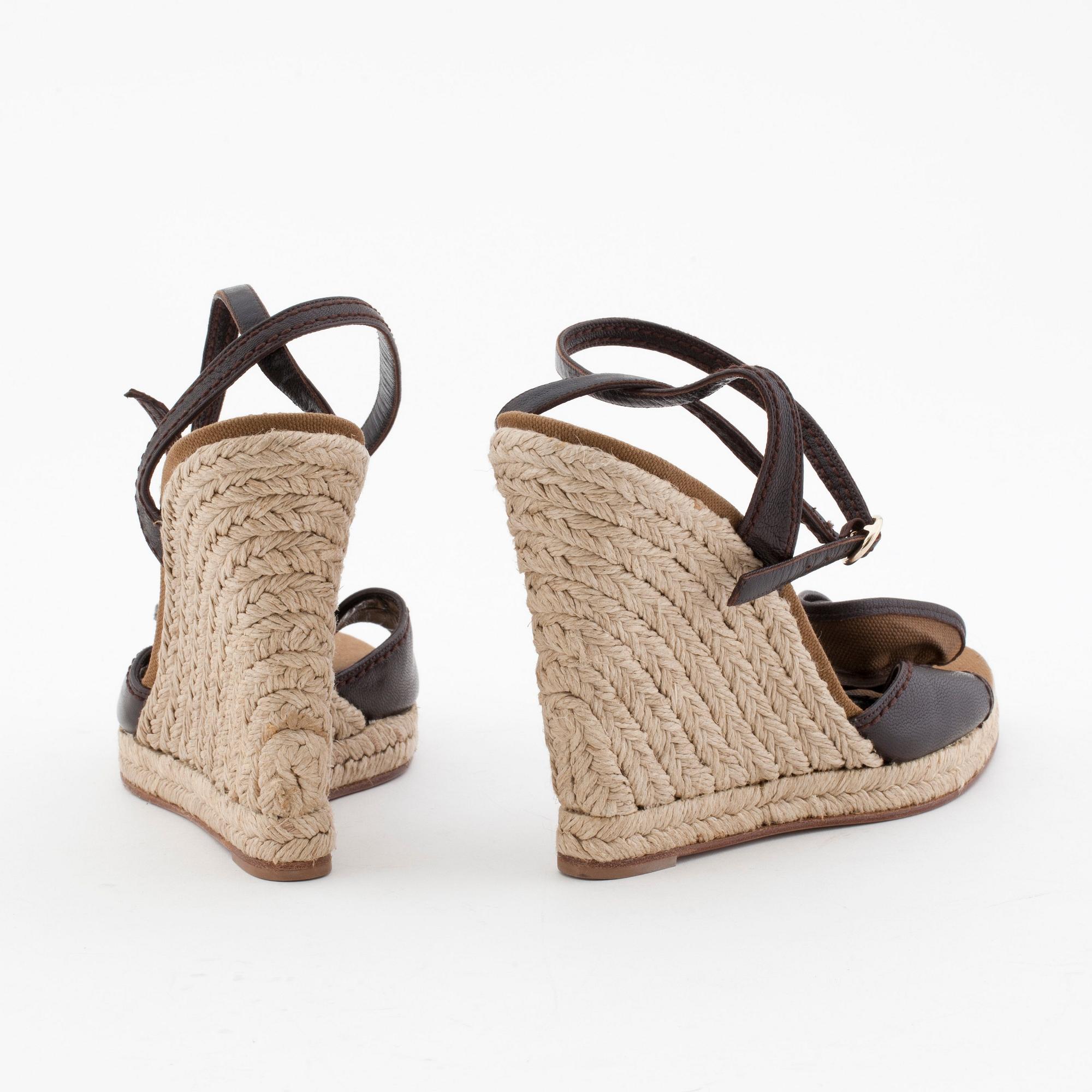 YVES SAINT LAURENT, a pair of straw and leather wedge sandals.