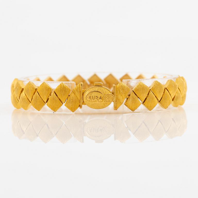 Garnityr av guldsmycken, en collier (14K), ett armband (18K), ett par örhängen (14K) och en ring (14K).