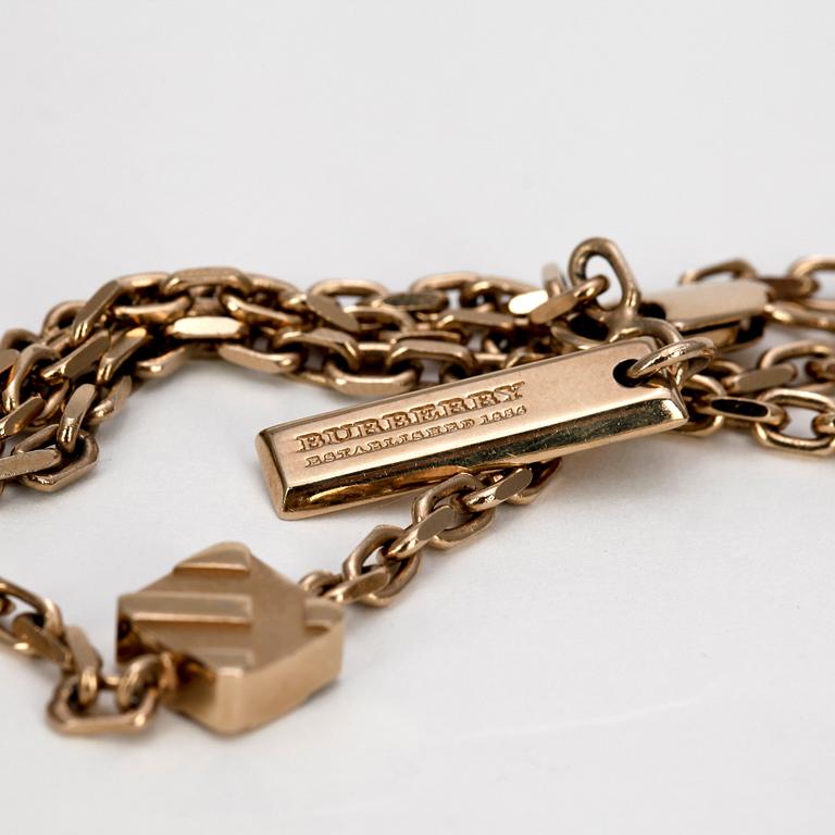 BURBERRY, a gold colored necklace.