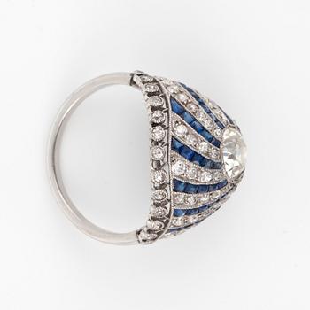 A 'spinning wheel' sapphire and diamond ring. Circa 1930. French hallmarks. Platinum. Size 16.50/52. Weight circa 5 g.