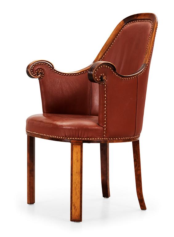 A Swedish easy chair in stained birch, upholstered in artificial leather, by NK, Nordiska Kompaniet, 1910's-20's.