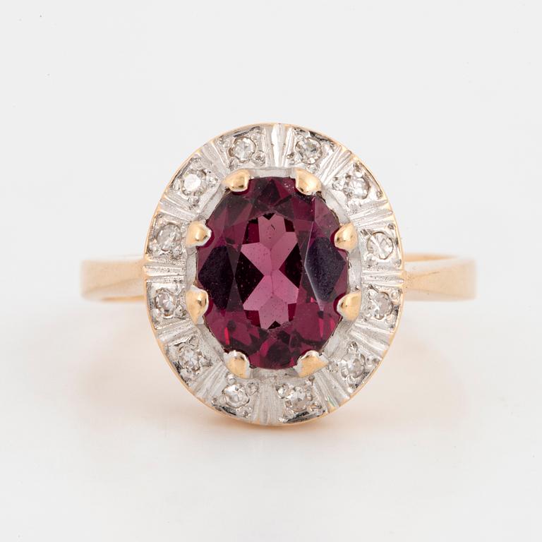 A 14K gold ring set with a garnet and eight-cut diamonds.