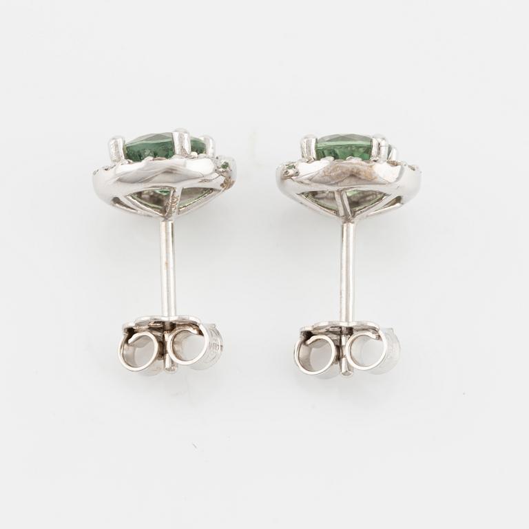 A pair of 18K gold earrings with green faceted sapphires and round brilliant-cut diamonds.