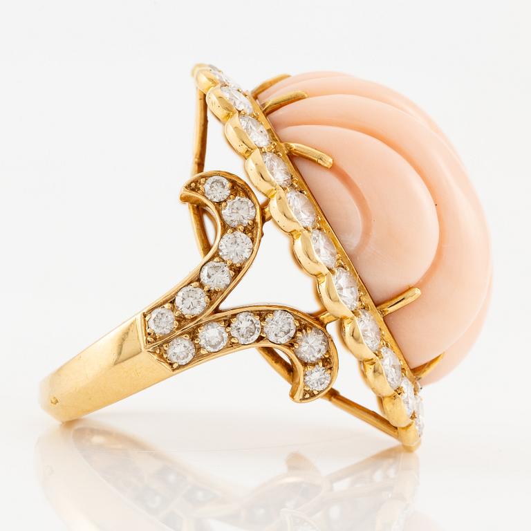 An 18K gold and coral Cartier ring set with round brilliant-cut diamonds.