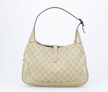 A beige monogram canvas handbag by Gucci.