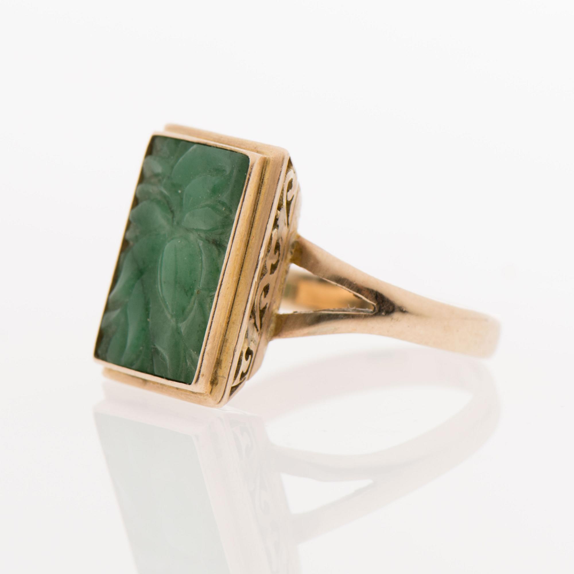 A RING, carved jade, 18K gold.