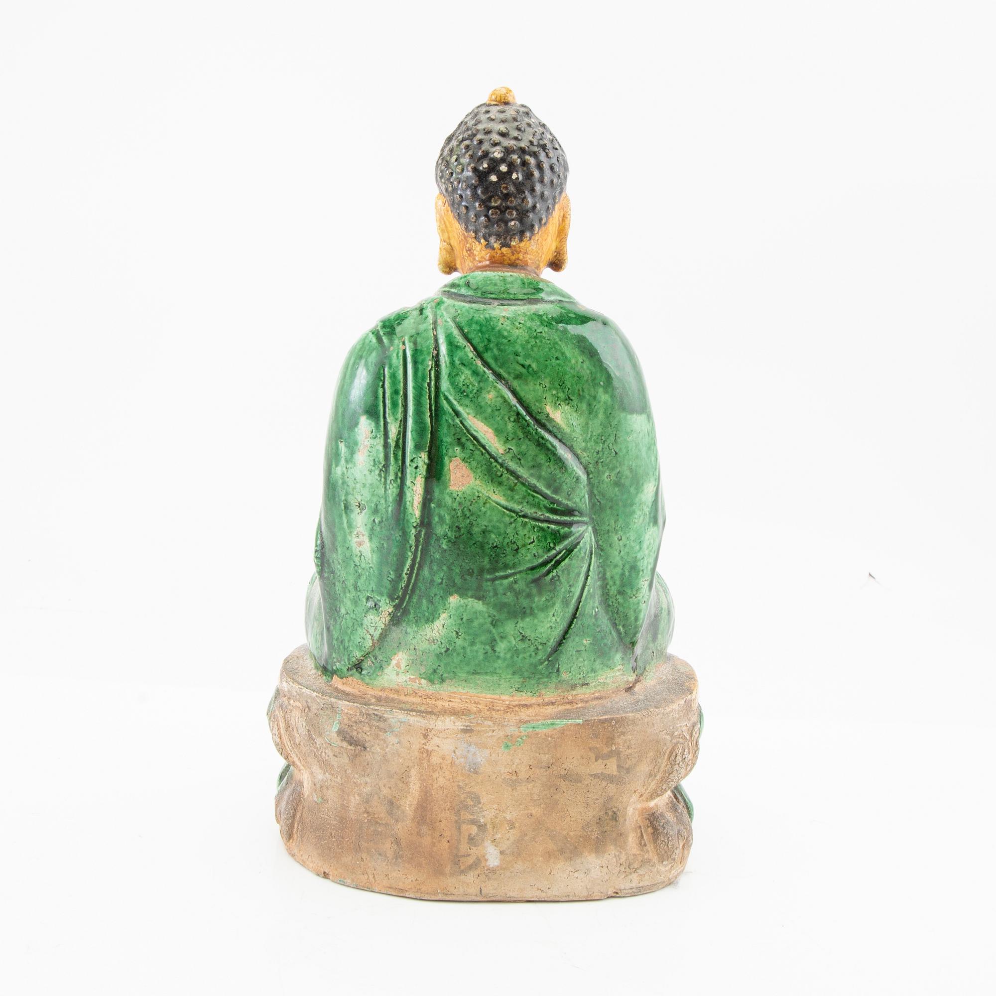 A green and yellow glazed figure of buddha, China, 20th century.