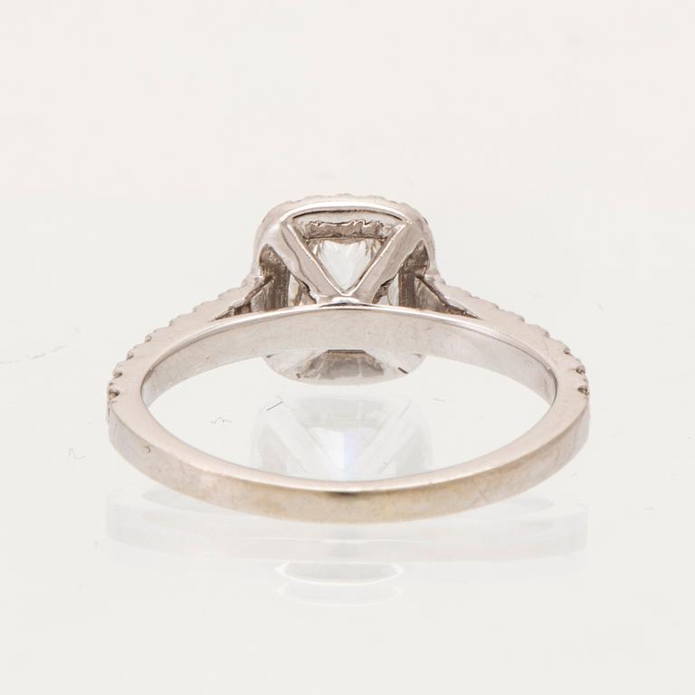 An 18K white gold ring set with a modified cushion-cut diamond and round brilliant-cut diamonds.