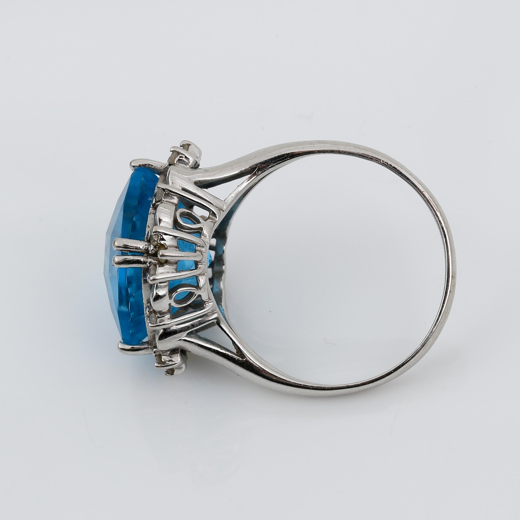RING, 14K vitguld med blå checkerslipad topas tot ca 2.77 ct omges av små åttkantslipade diamanter. Vikt 4.56 g.