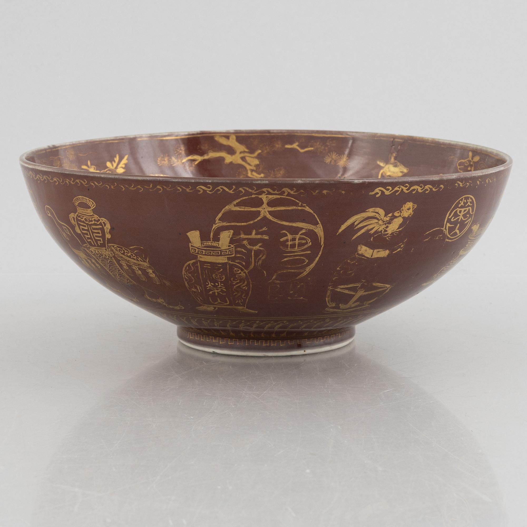A brown glazed bowl with gilded decoration of animals and antiques, Qing dynasty, 19th century.