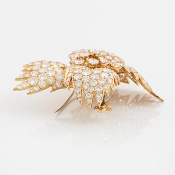A Van Cleef & Arpels flower brooch in 18K gold set with round brilliant-cut diamonds.