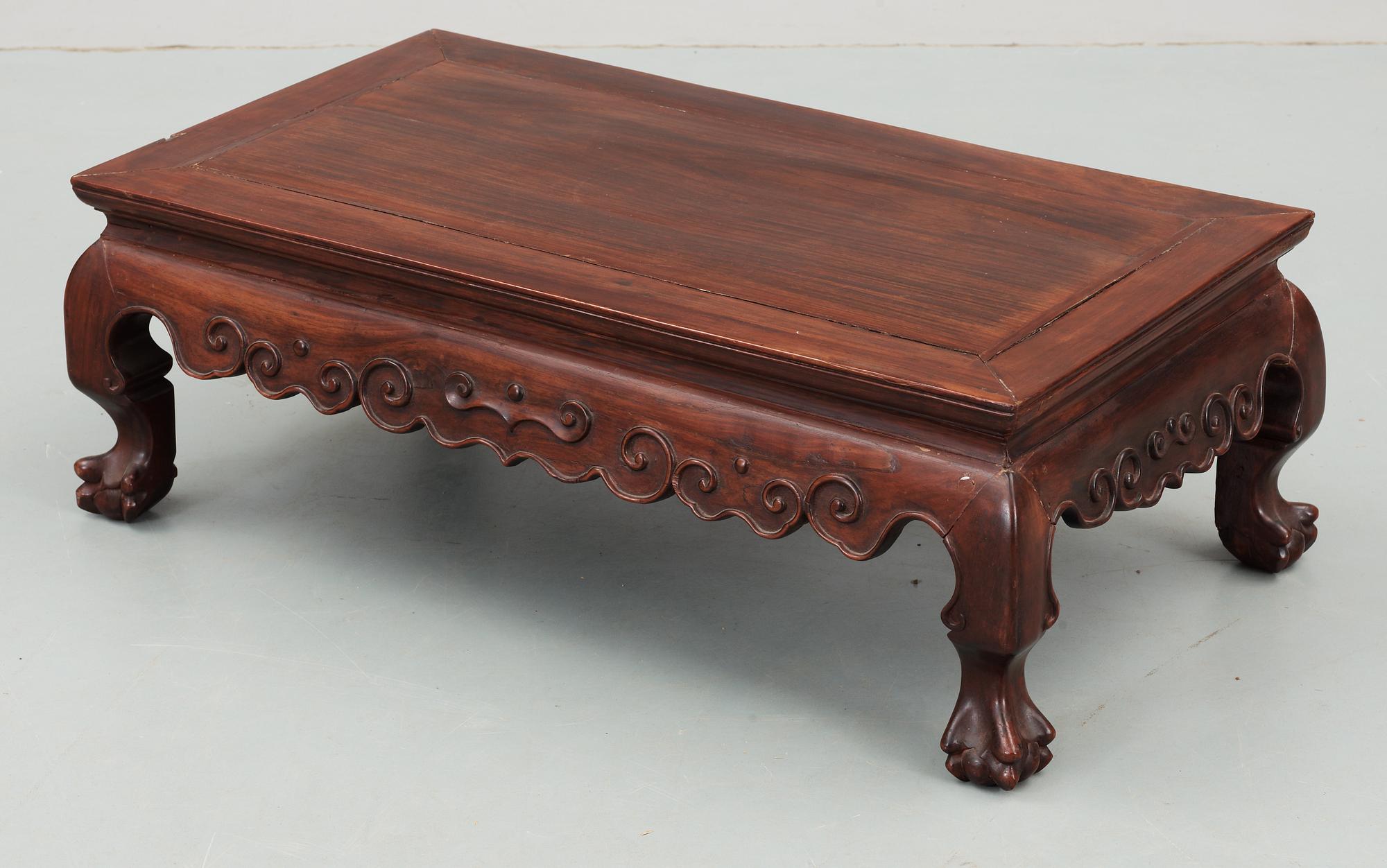 A hardwood 'claw on ball' low table, Qing dynasty.