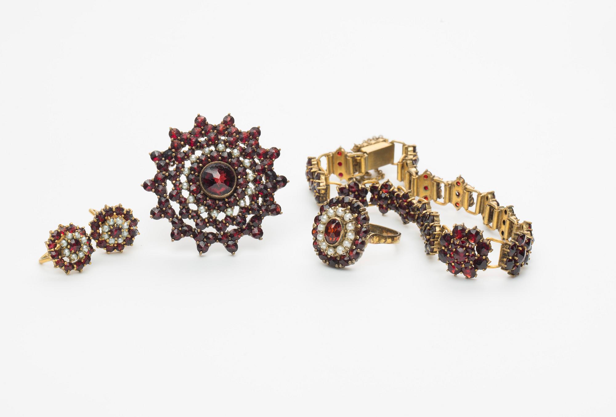 BROSCH, RING, ARMBAND, ÖRHÄNGEN, ett par, förgylld metall med granater samt pärlor.