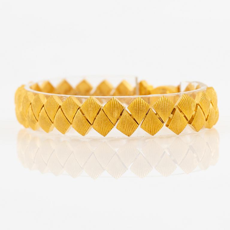 Garnityr av guldsmycken, en collier (14K), ett armband (18K), ett par örhängen (14K) och en ring (14K).