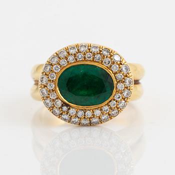 Ring med ovalslipad smaragd och krans med briljantslipade diamanter.