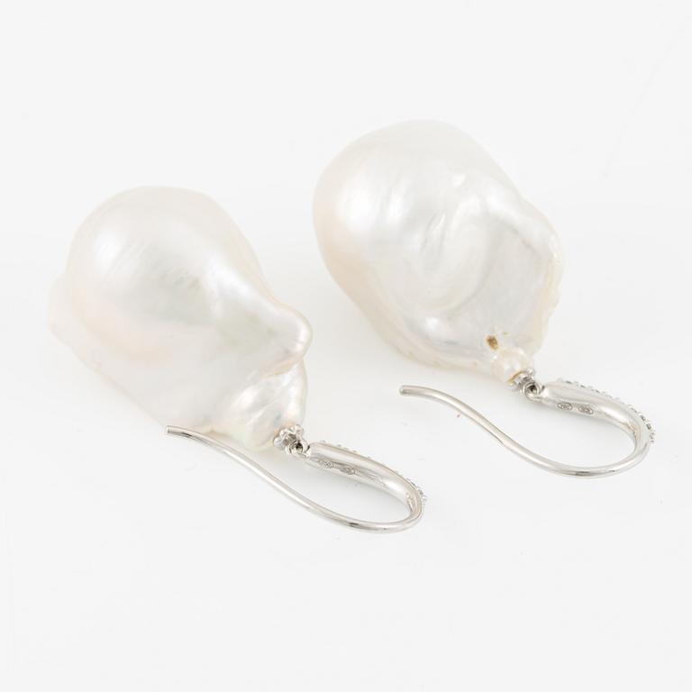 A pair of earrings in 18K gold with baroque-shaped cultured freshwater pearls and round brilliant-cut diamonds.