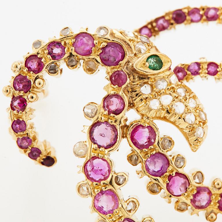 An Ilias Lalaounis brooch in 18K gold set with faceted rubies, an emerald and rose-cut diamonds.