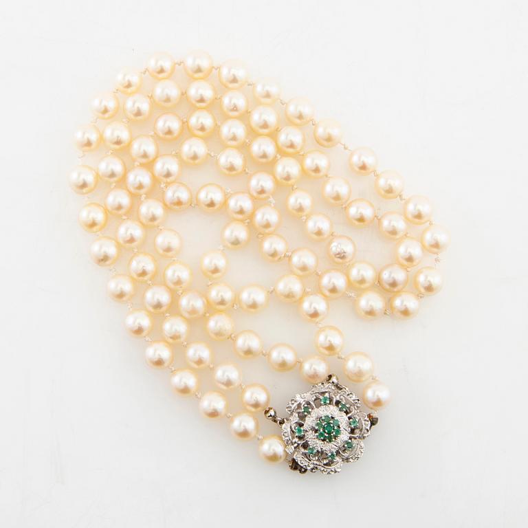 Necklace double-stranded of cultured pearls with a clasp of 18K white gold and emeralds.