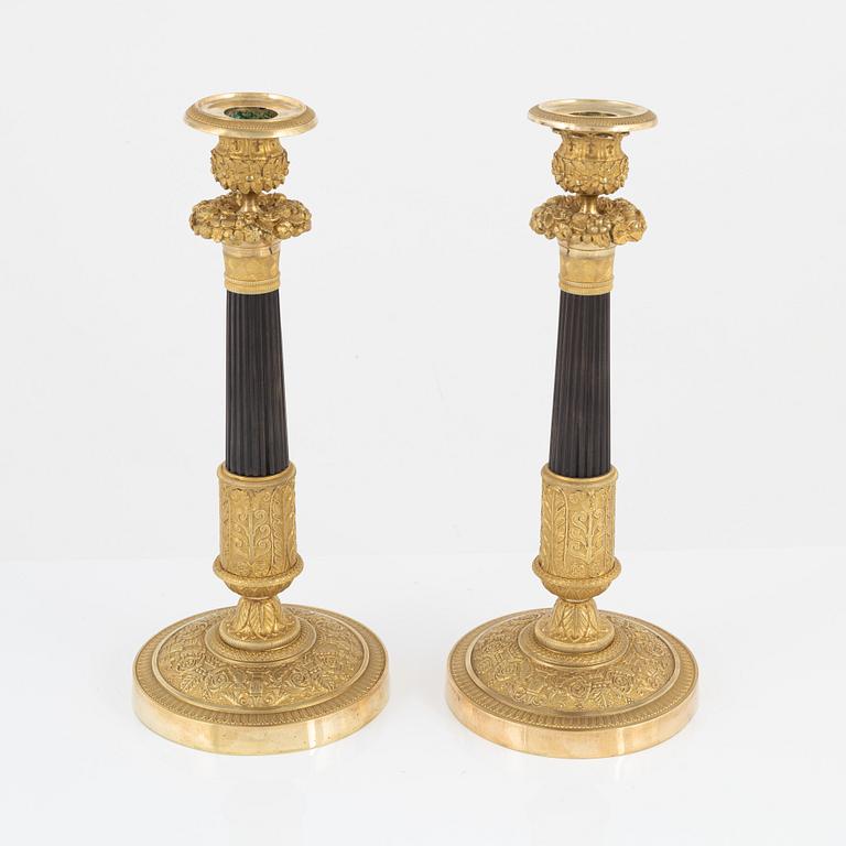 A pair of French Empire ormolu and patinated bronze candlesticks, early 19th century.