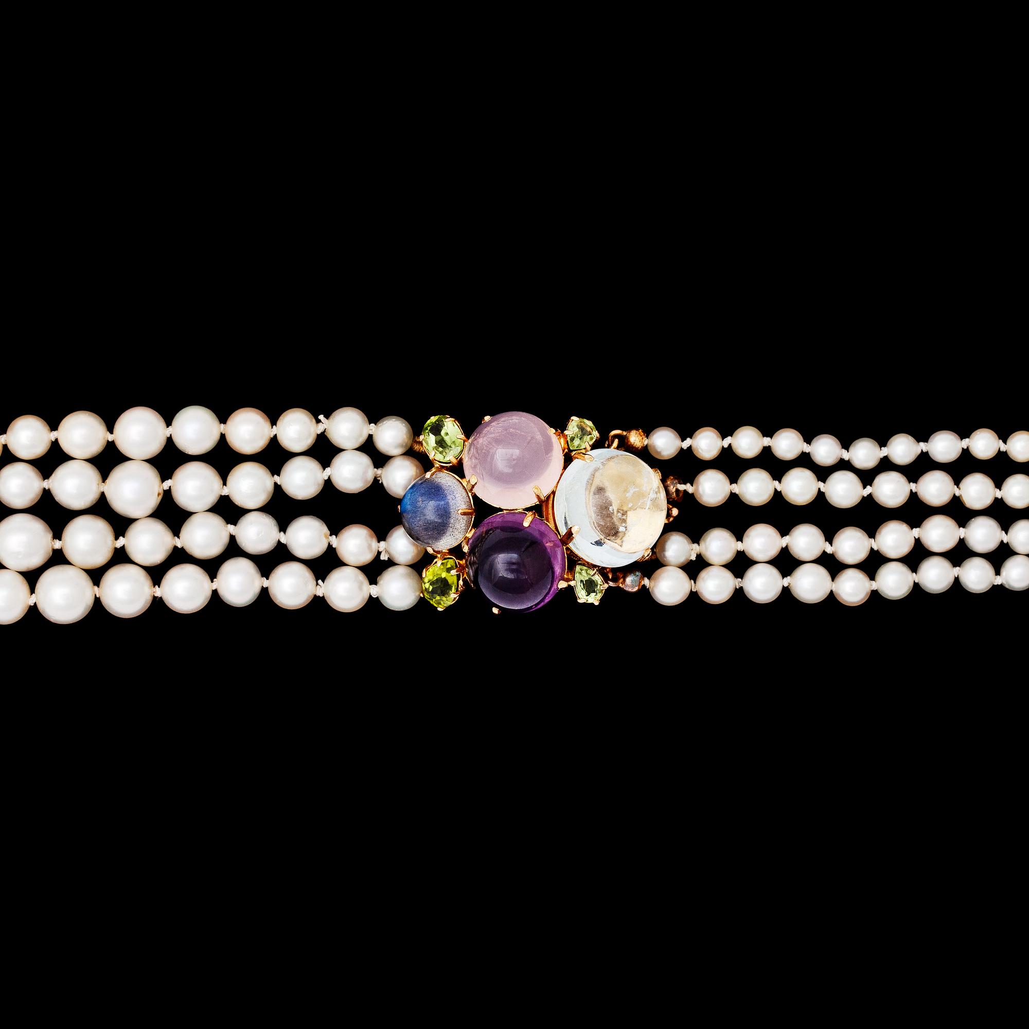A four strand cultured pearl necklace with cabochon cut amethyst, rose quartz and aquamarine.