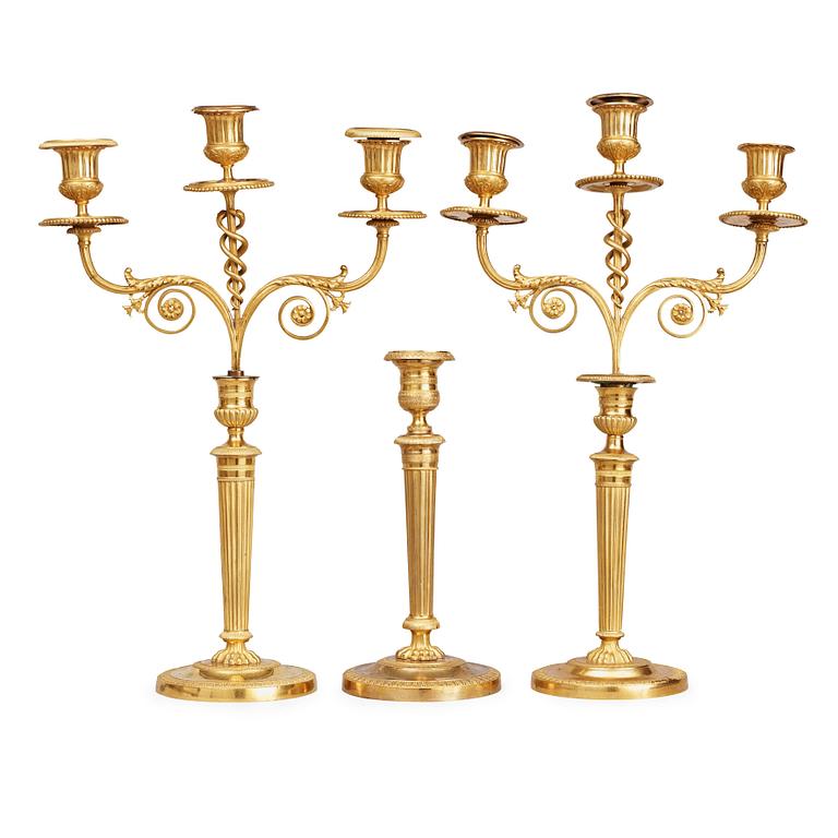 A matched pair Empire early 19th century gilt bronze candelabra/candlesticks. Including one empire candlestick.