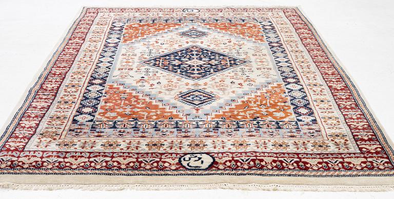 A signed oriental carpet, approx. 268 x 182 cm.