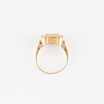 Ring in 18K gold with a quartz crystal and small white stones.