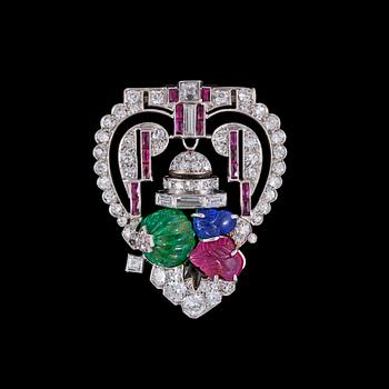 972. BROSCH/CLIP, skuren smaragd, rubin och safir med baguette- och åttkantslipade diamanter. Art Deco, ca 1925.