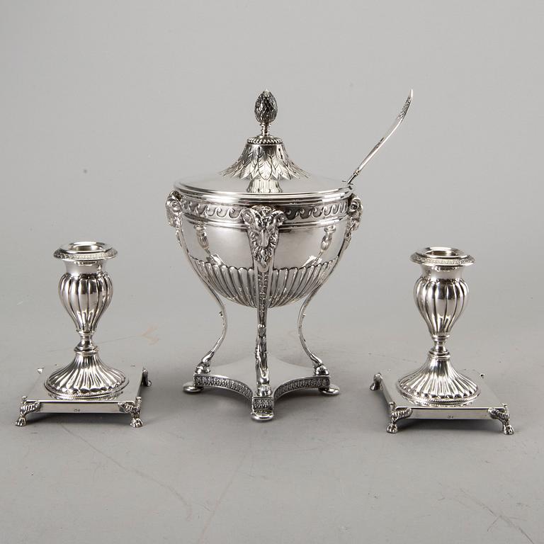 A silver bowl on foot, a pair of candlesticks and a spoon. early 20th century. Total weight app. 800 gram.