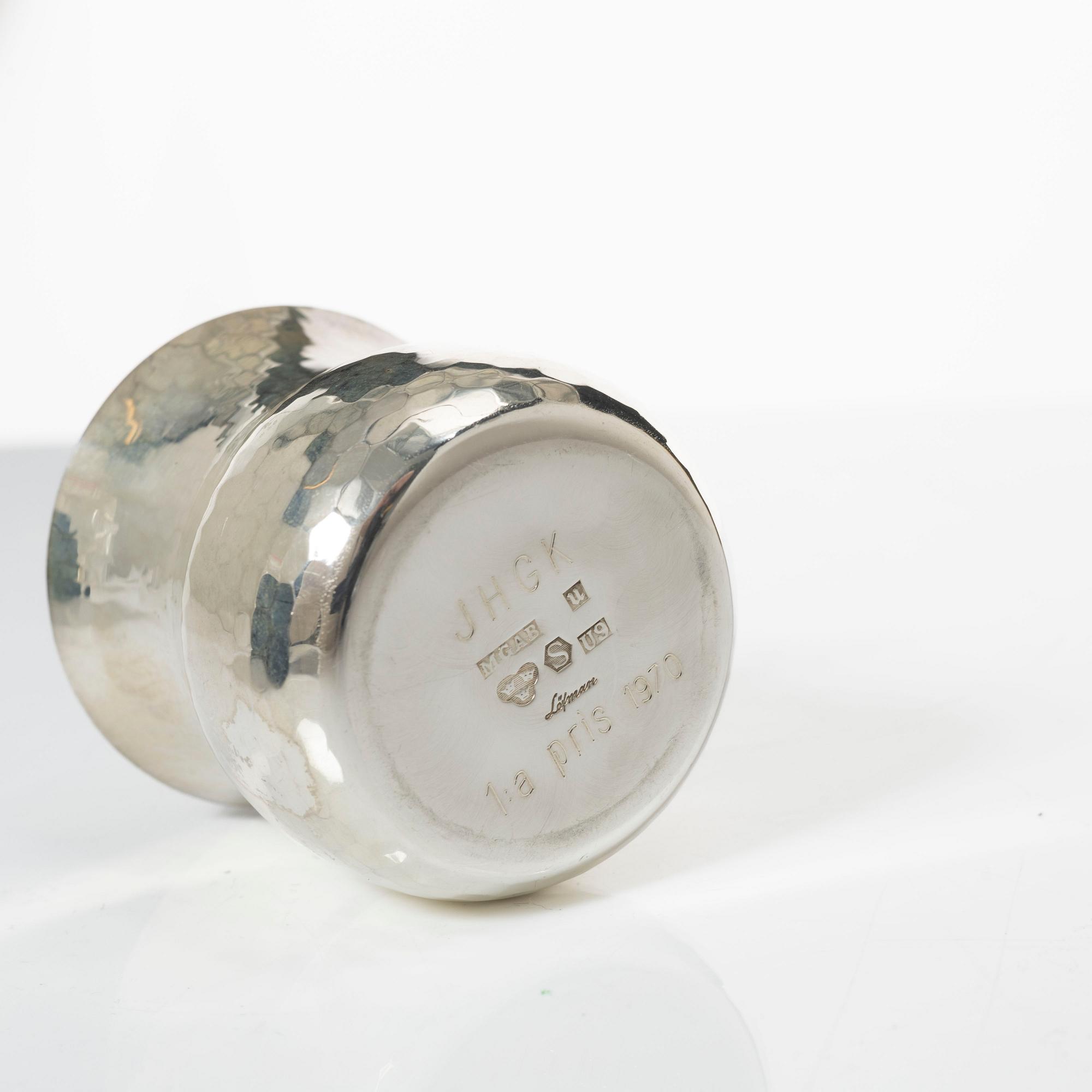 A pair of beakers, two napkin rings, and 17 pieces of cutlery, silver.