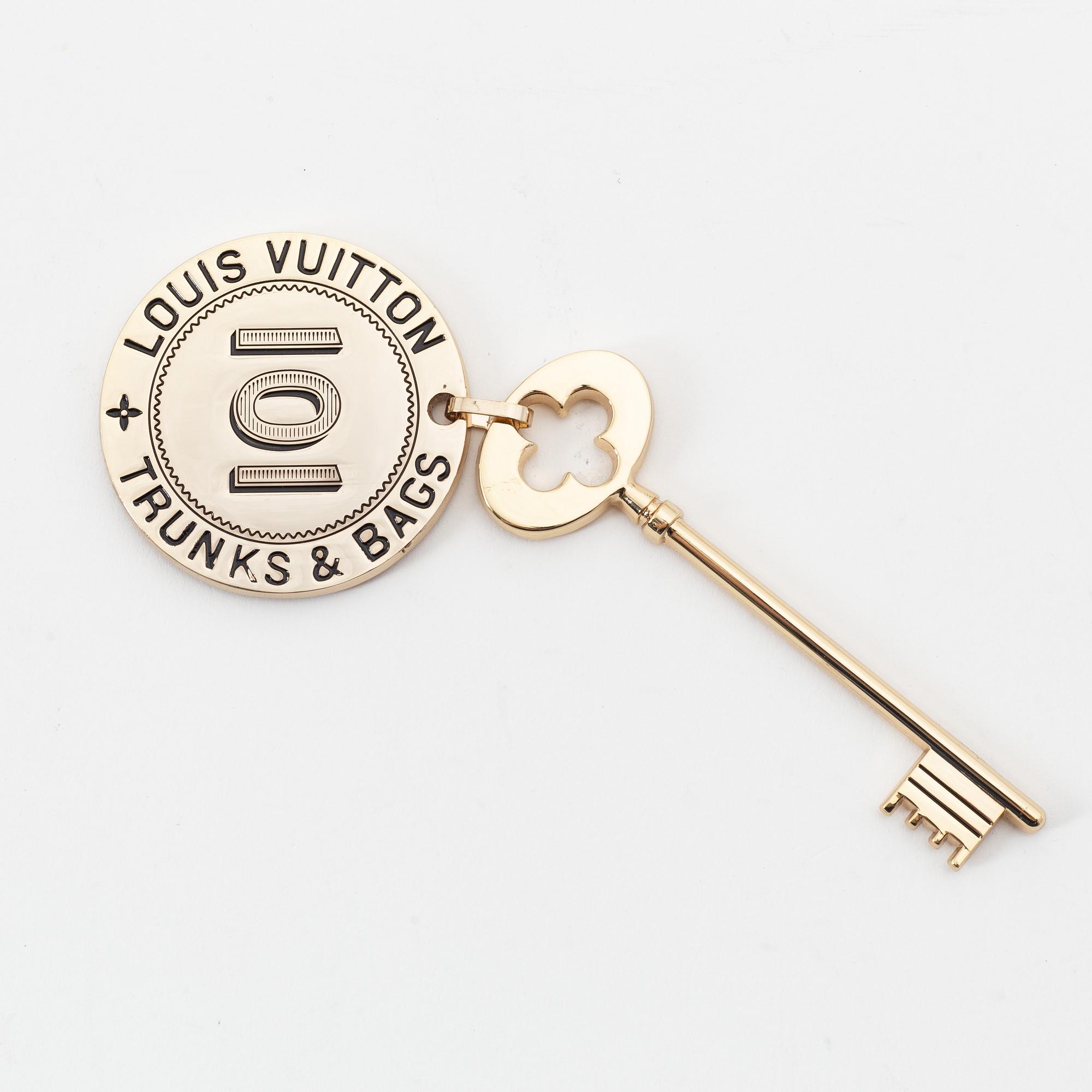 Louis Vuitton, a gold metal key magnet.