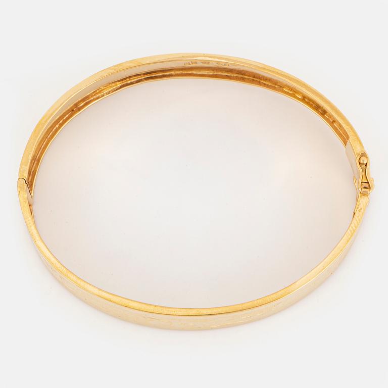 An 18K gold bangle.