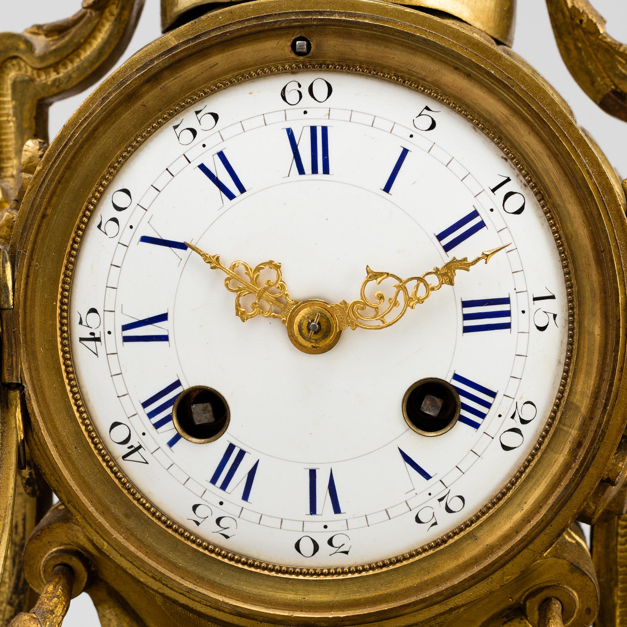 A table CLOCK and a pair of candelabra, second part of 19th century.