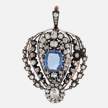 1035. A silver and 14K gold brooch/pendant set with a faceted sapphire and old-cut diamonds.