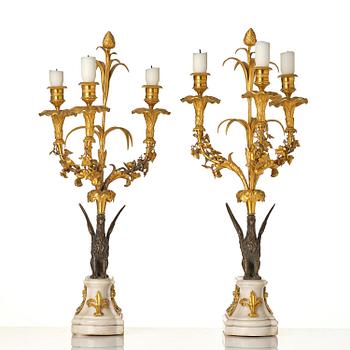 A pair of three-light Louis XVI patinated and ormolu candelabra in the manner of François Rémond, late 18th century.